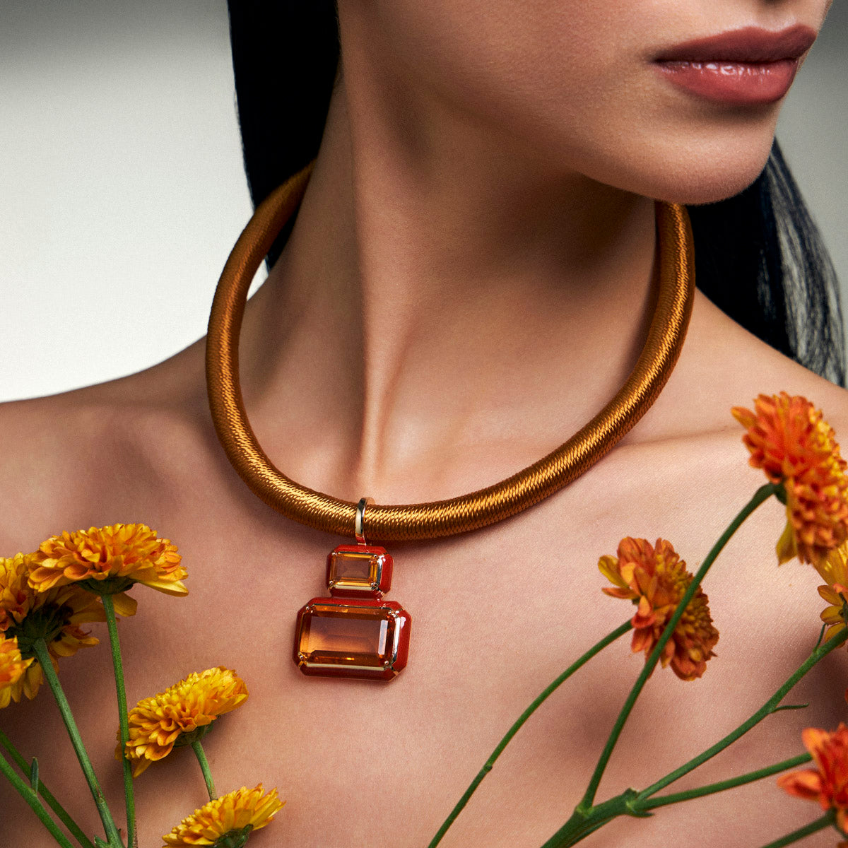 Woman wearing a deep gold waxed cord necklace with a statement pendant