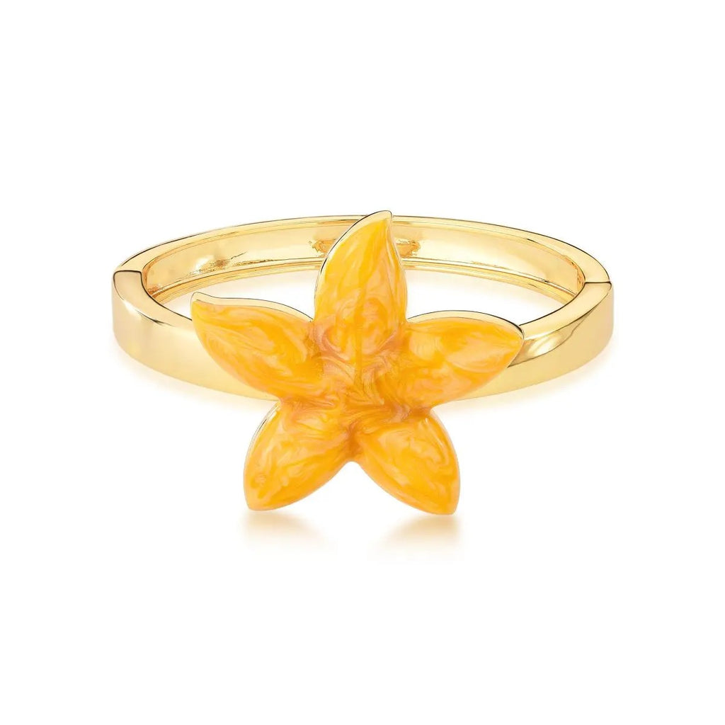 Gold ring with a yellow flower-shaped stone on a white background