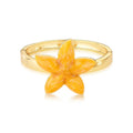 Gold ring with a yellow flower-shaped stone on a white background