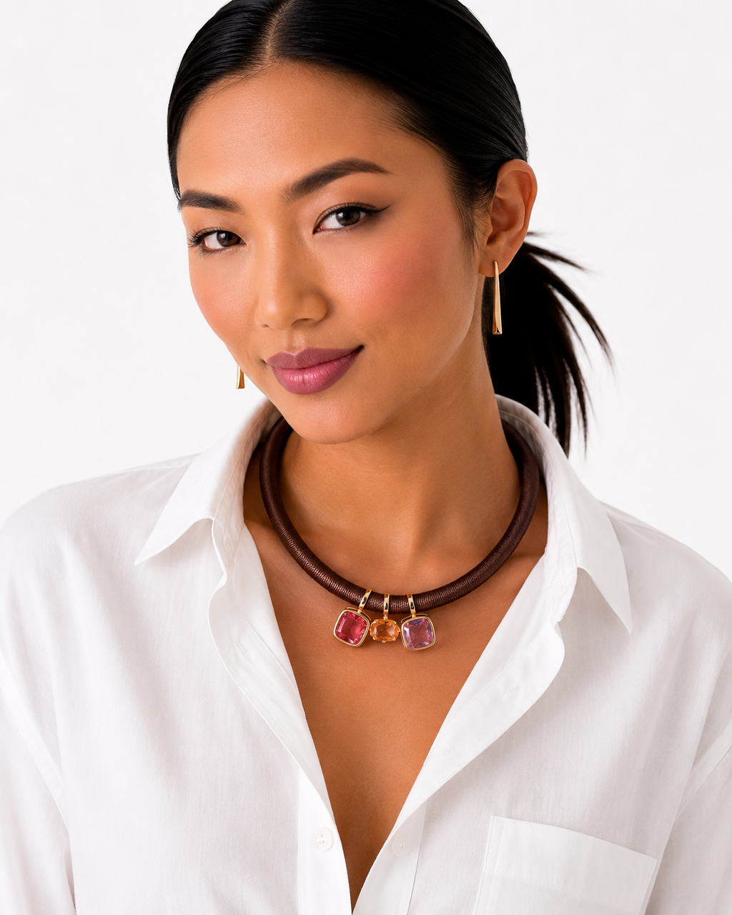 Woman wearing a white shirt and a necklace with pink gemstones on a white background