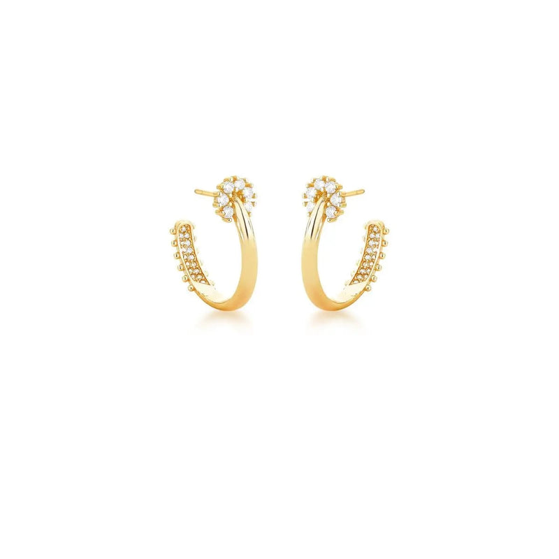 Gold hoop earrings with small zirconias on a white background