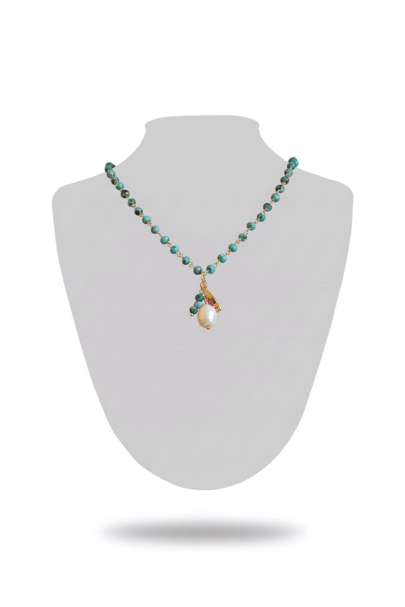 Necklace with turquoise beads and a pendant on a white mannequin bust.