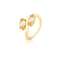 Gold ring with peach-colored gemstones on a white background