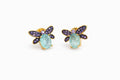 Dragonfly-shaped earrings with gemstones on a white background
