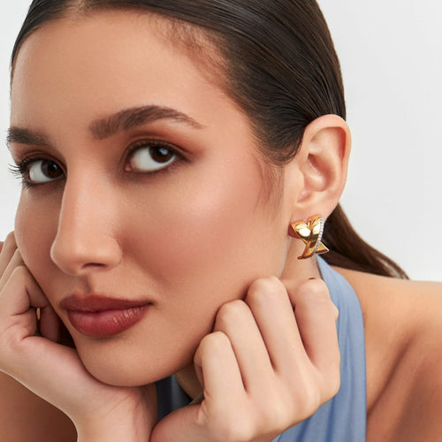 18K gold-plated crossover earrings featuring pavé zirconia in a woman close-up
