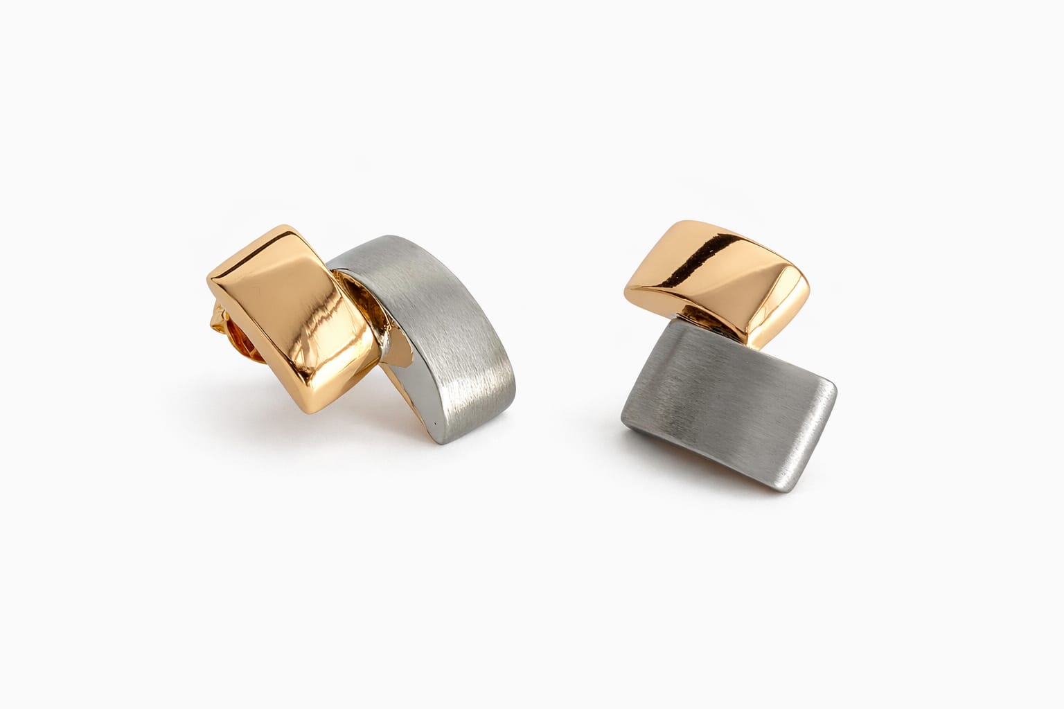 Pair of gold and silver geometric earrings on a white background